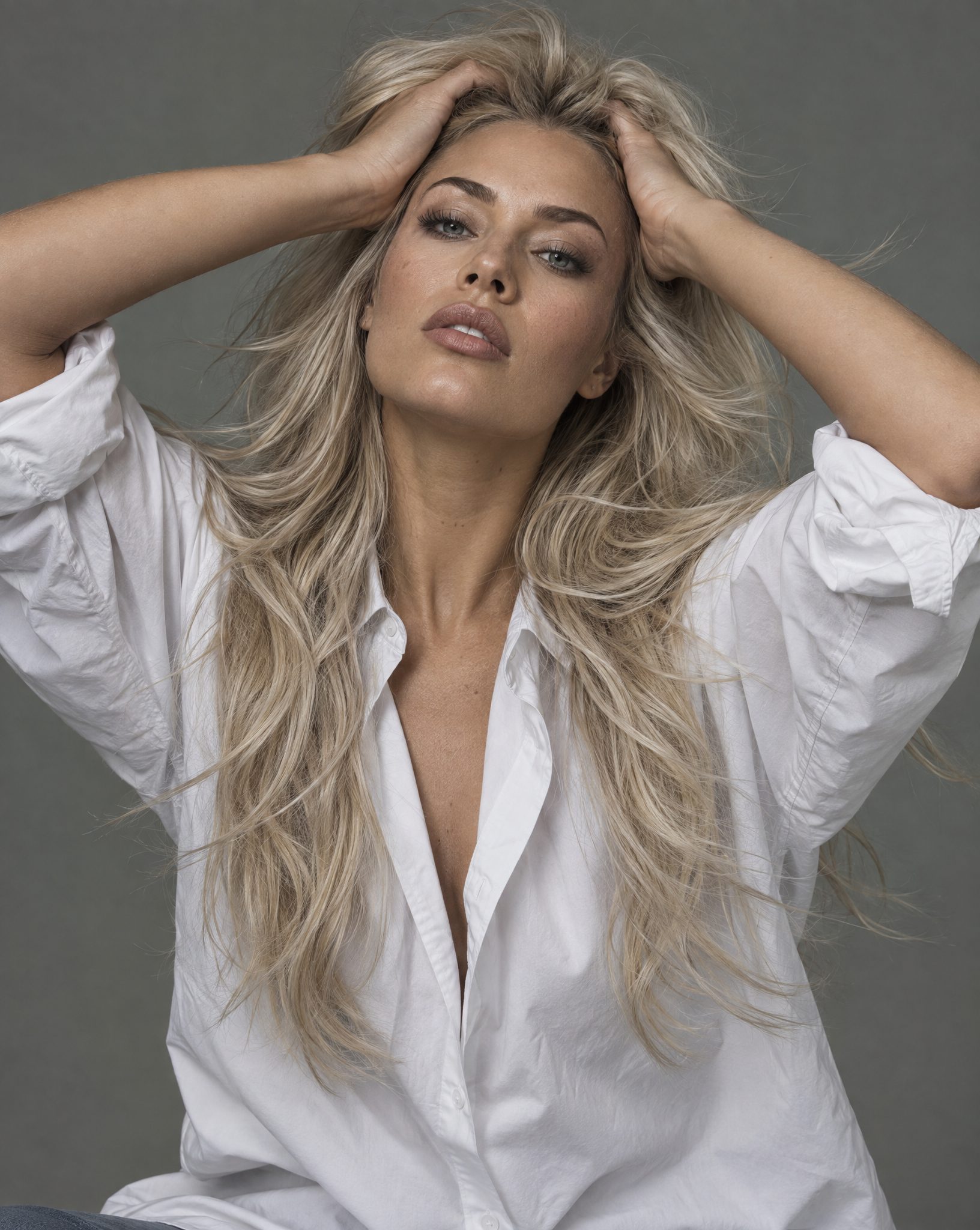 Model met lang blond haar, handen in het haar